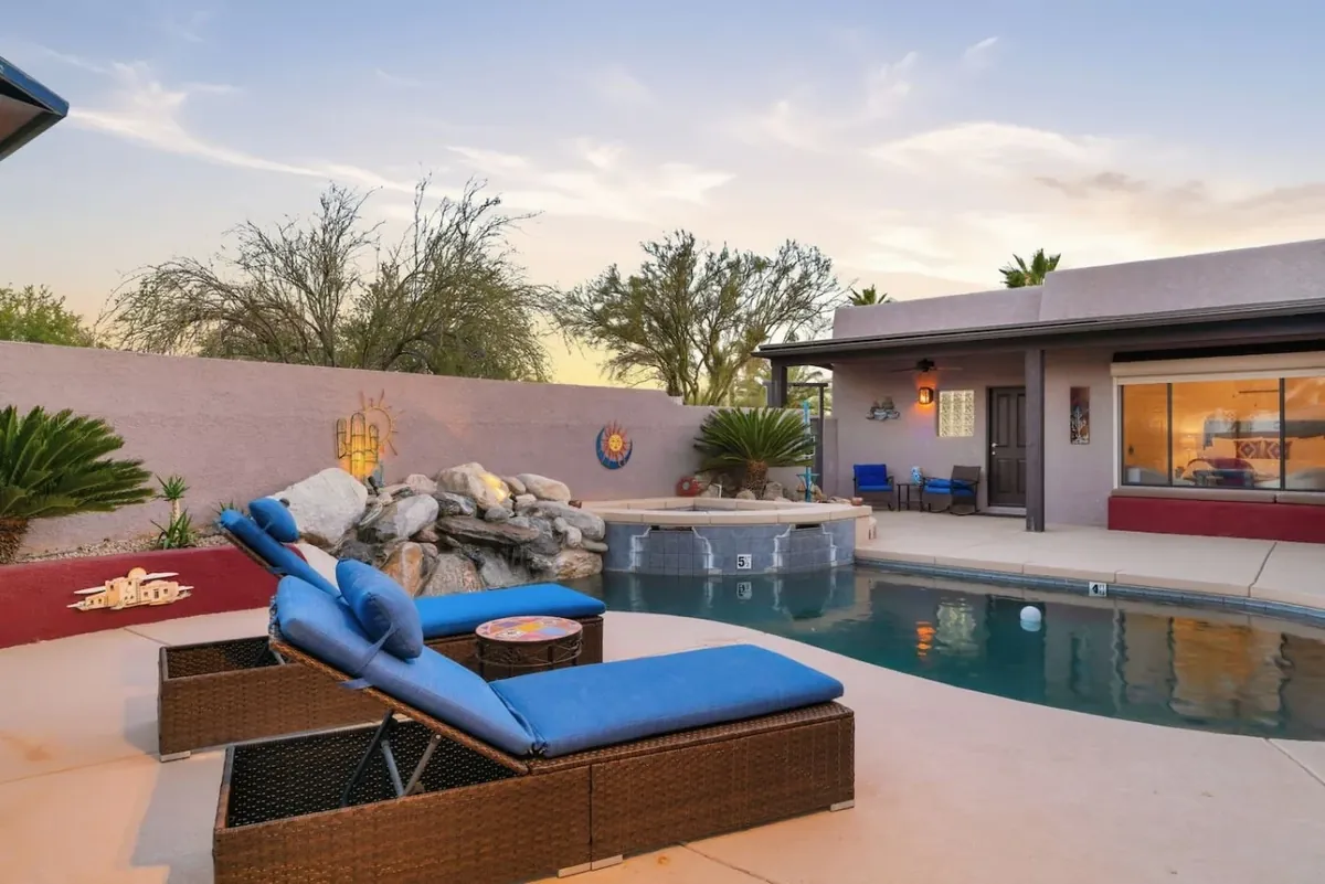 Tucson home pool and covered patio surrounded by desert plants at sunset